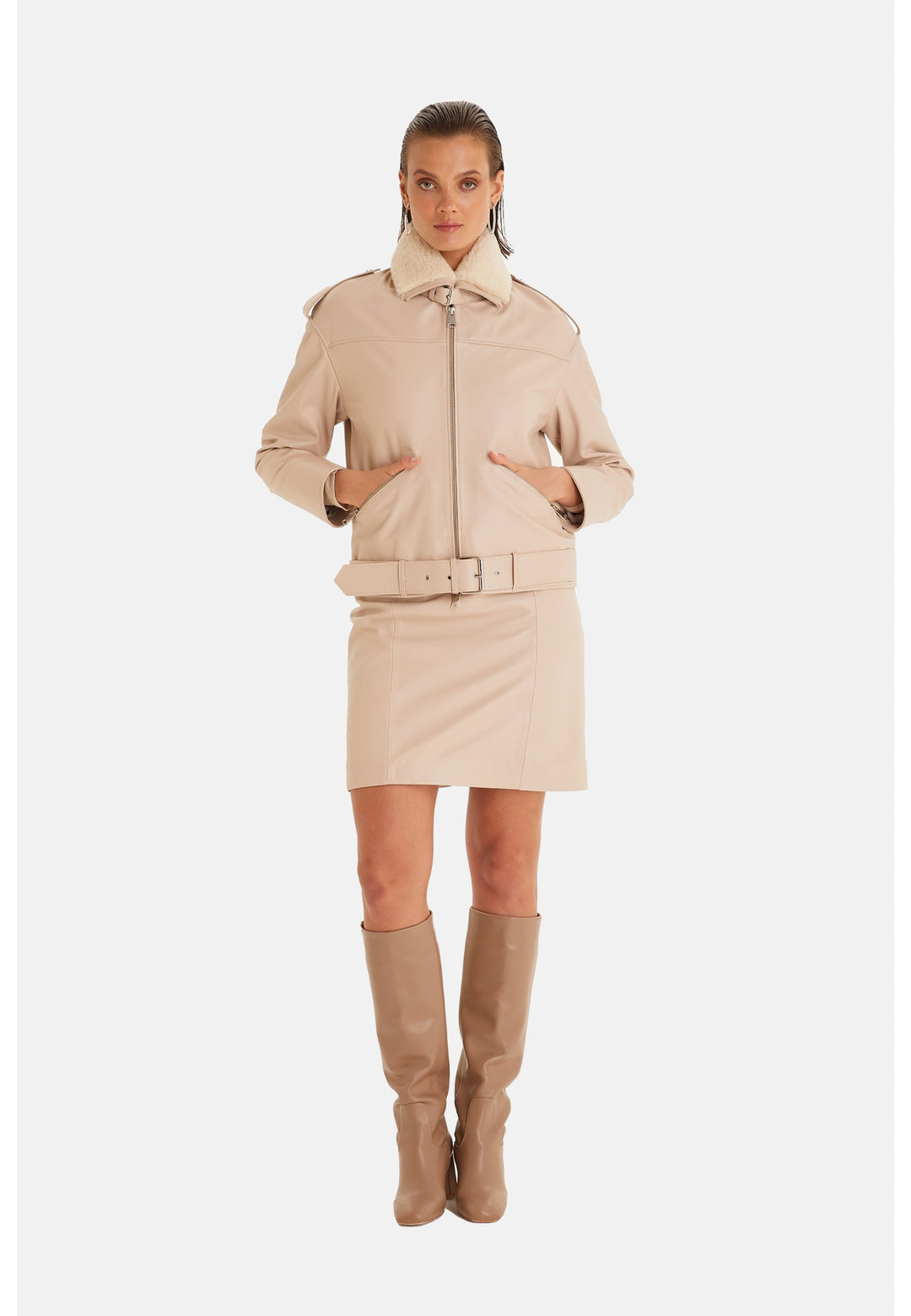 Woman wearing beige leather jacket and skirt