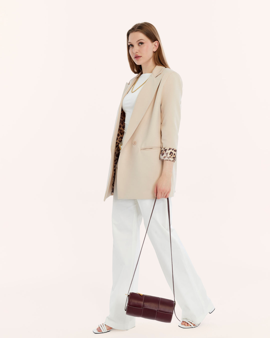 Woman in beige blazer with burgundy handbag