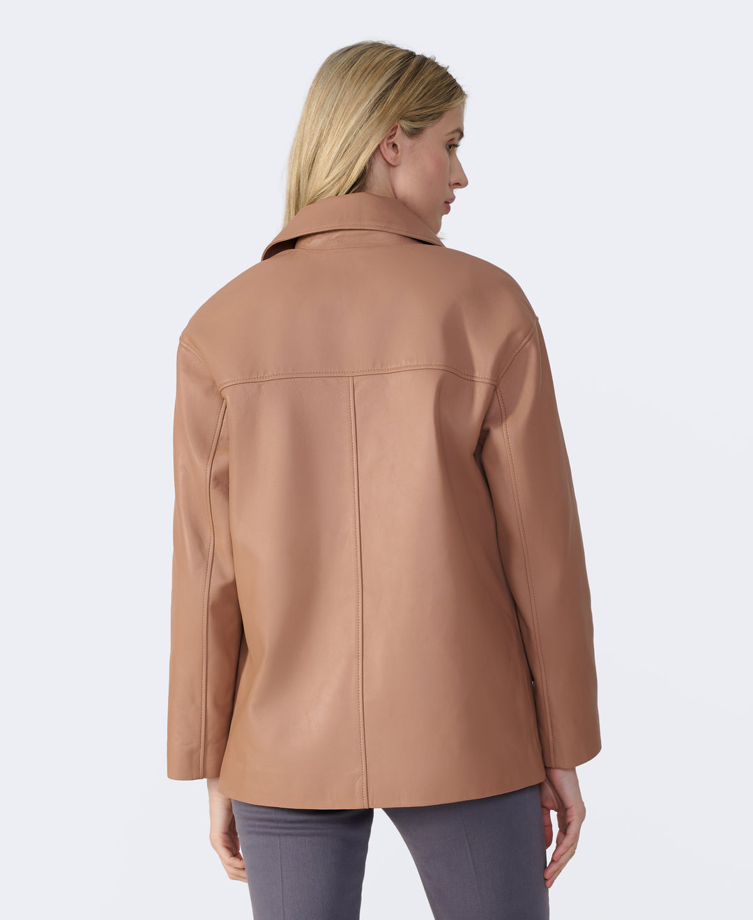 Woman wearing tan leather jacket (back view)