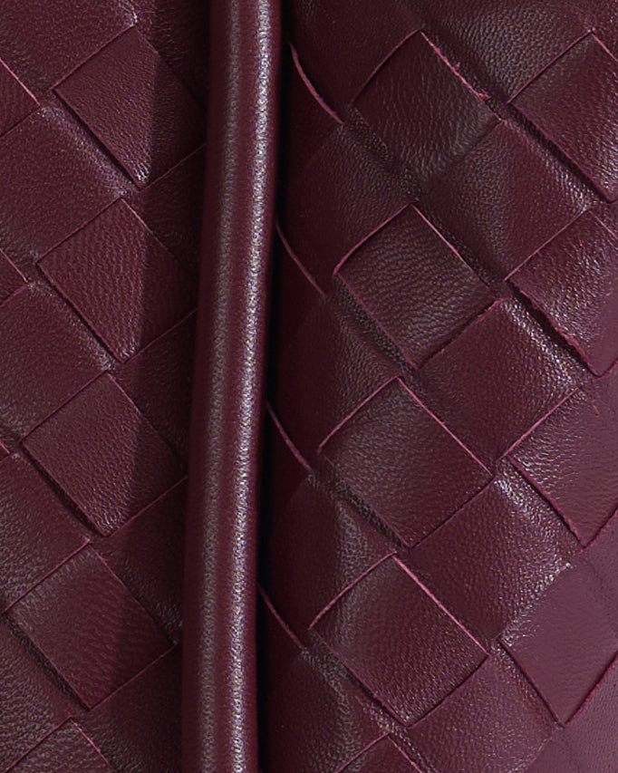 Close-up of burgundy woven leather bag