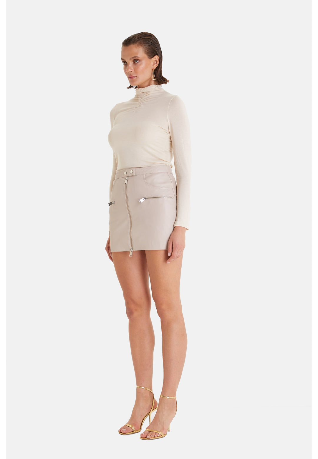Woman wearing beige leather mini skirt