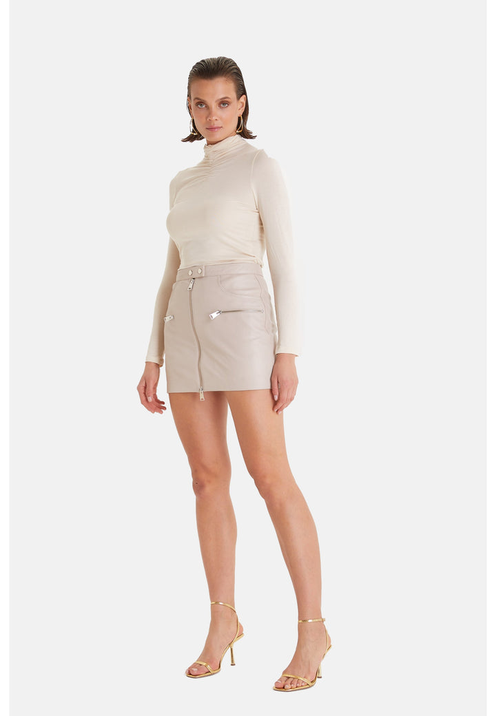 Woman wearing beige leather mini skirt