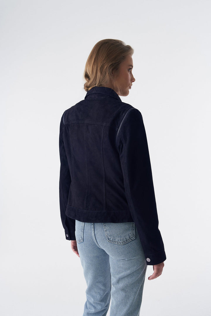 Woman wearing navy suede jacket - back view