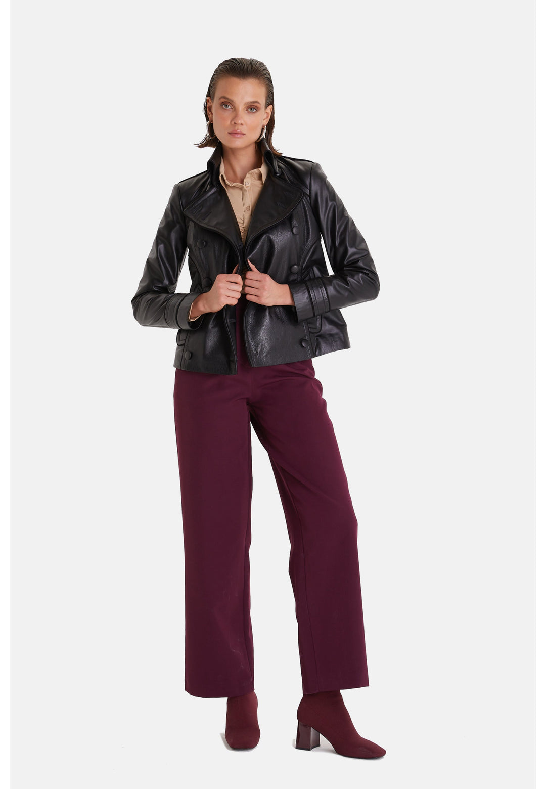 Woman wearing black leather jacket - burgundy trousers