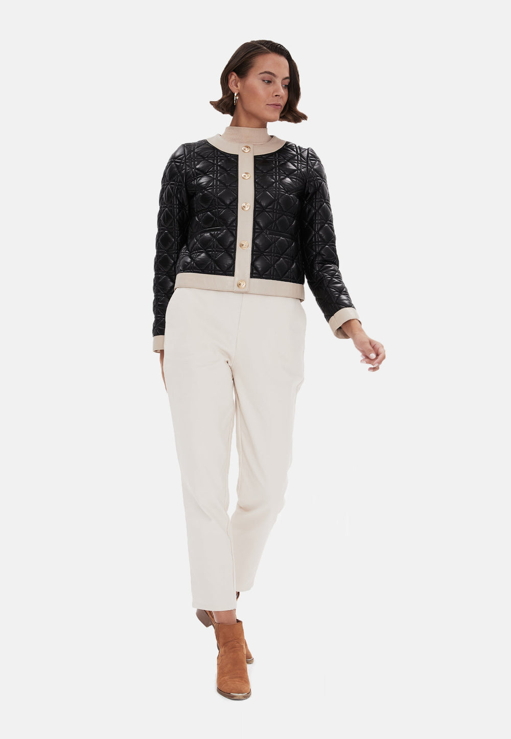 Woman wearing black quilted jacket and cream trousers