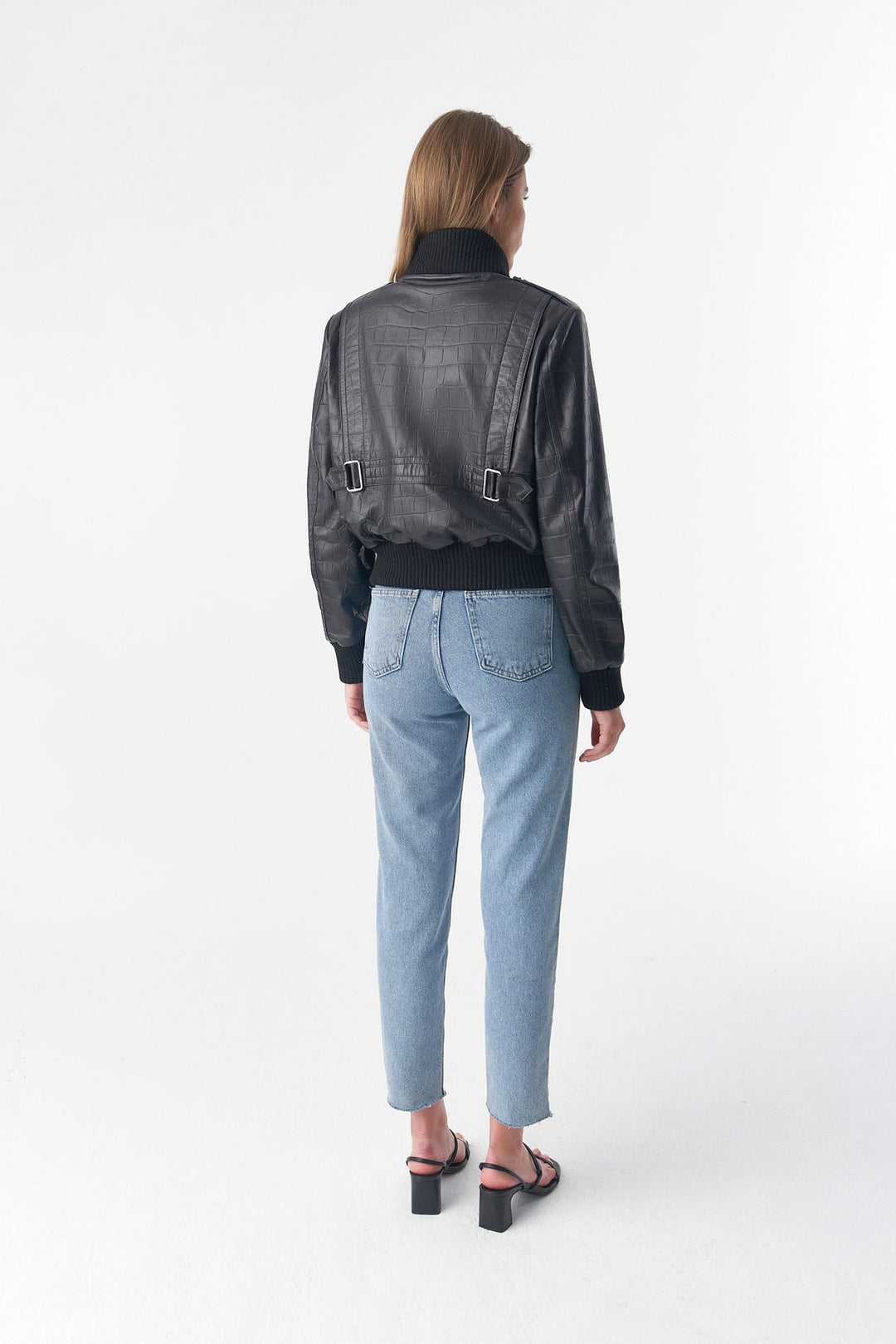 Woman wearing black bomber jacket (back)