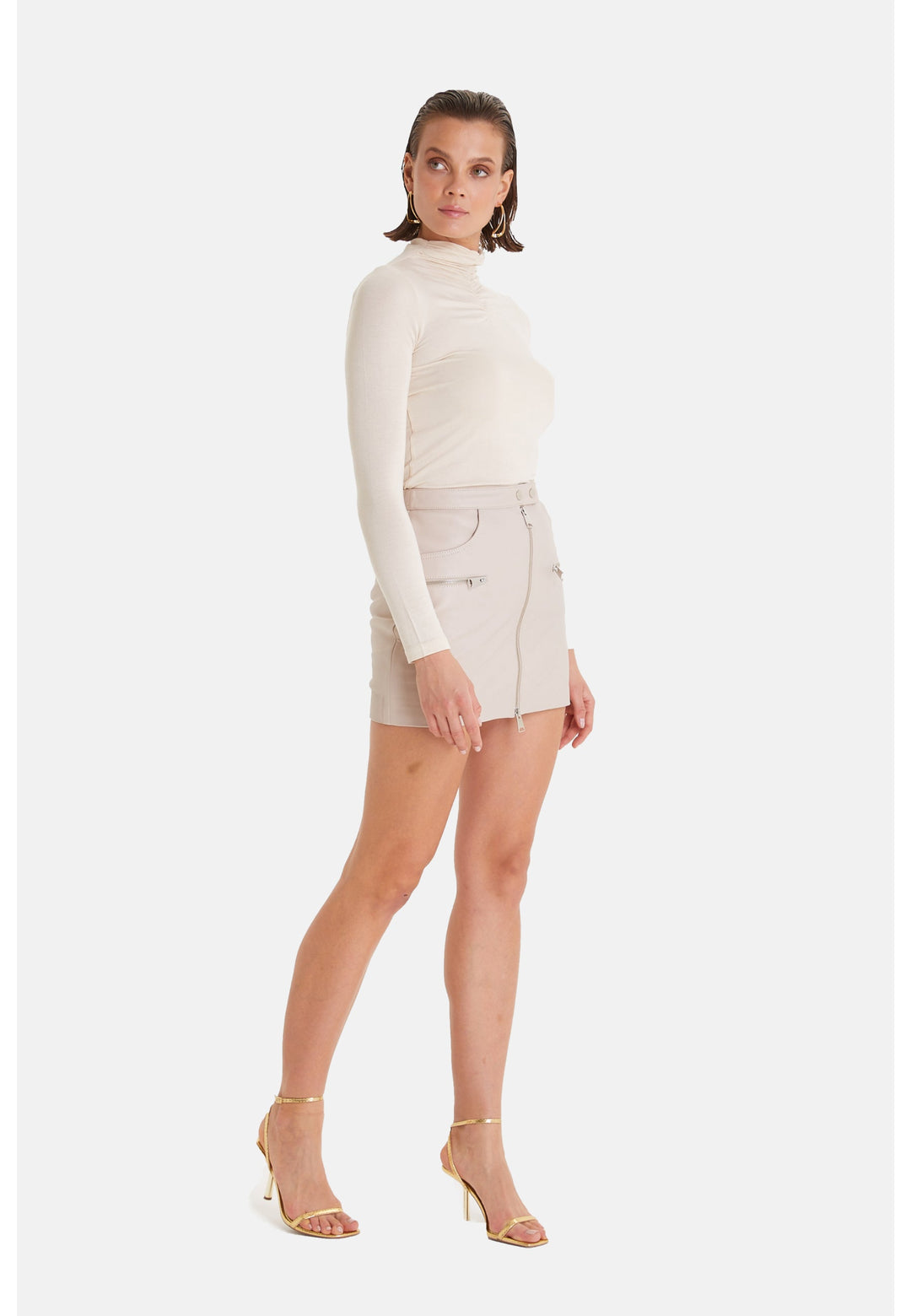 Woman wearing beige leather mini skirt