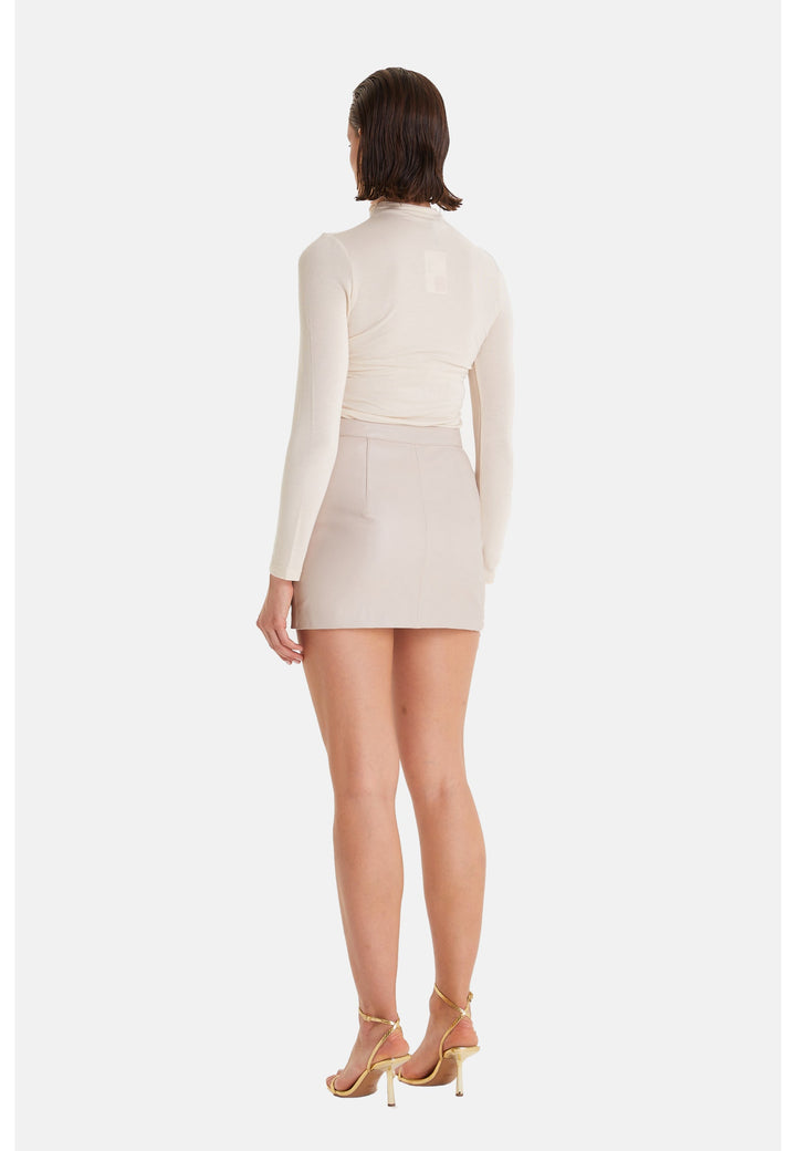 Woman wearing beige leather mini skirt