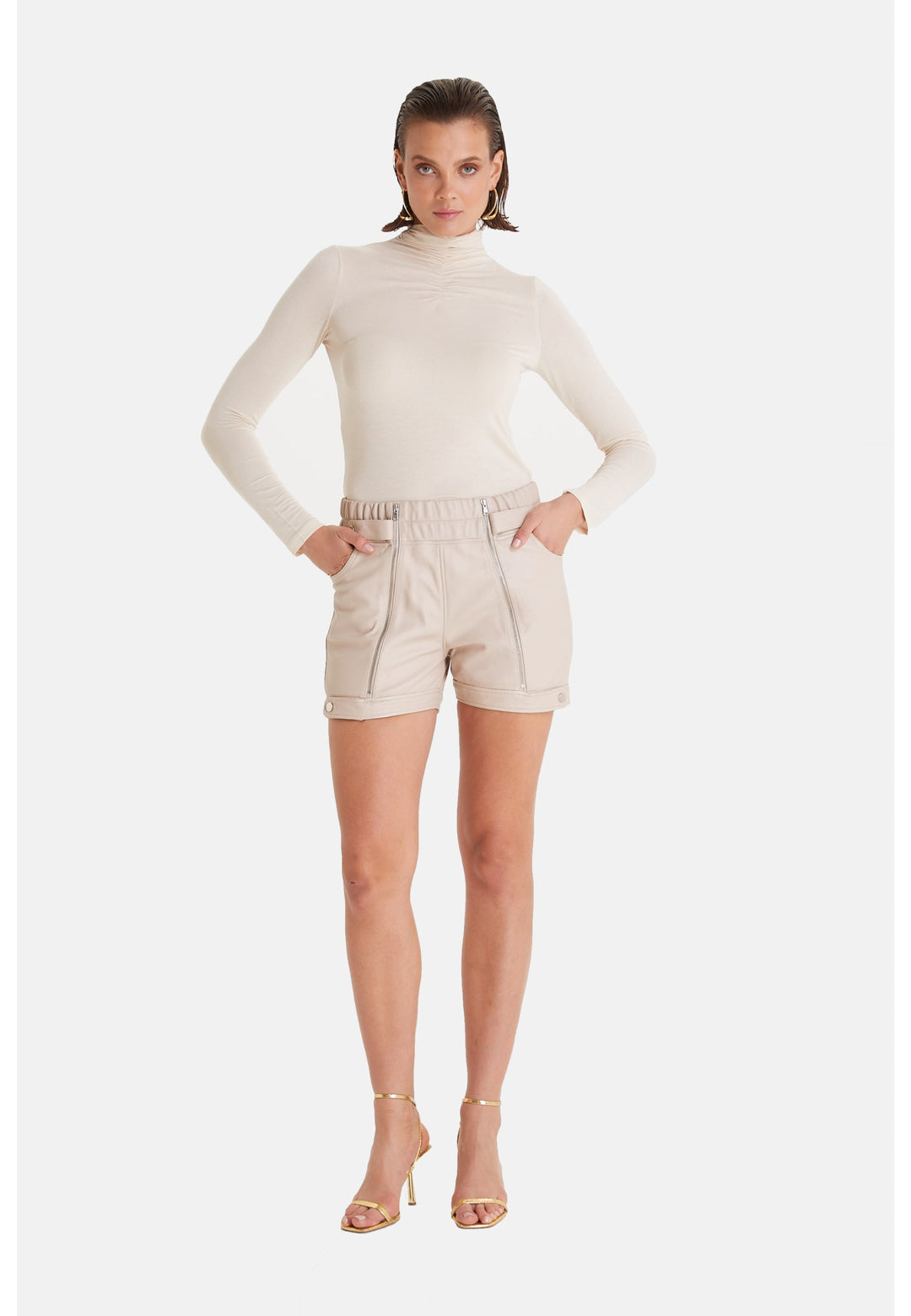 Woman wearing beige leather shorts