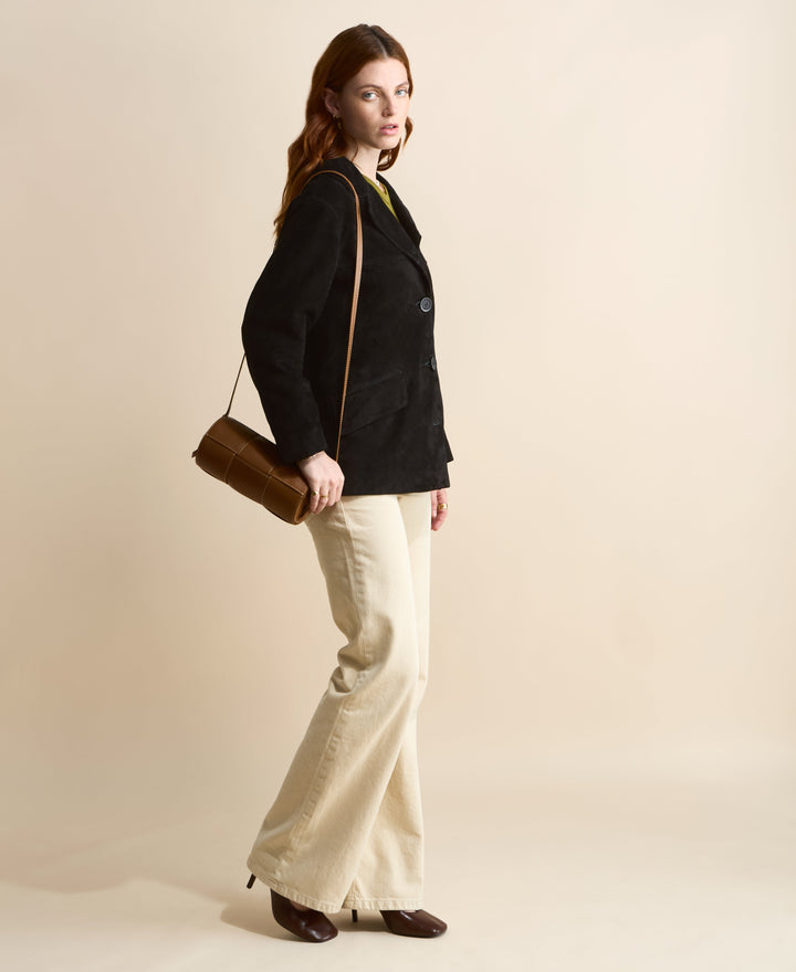 Tan woven leather handbag on shoulder