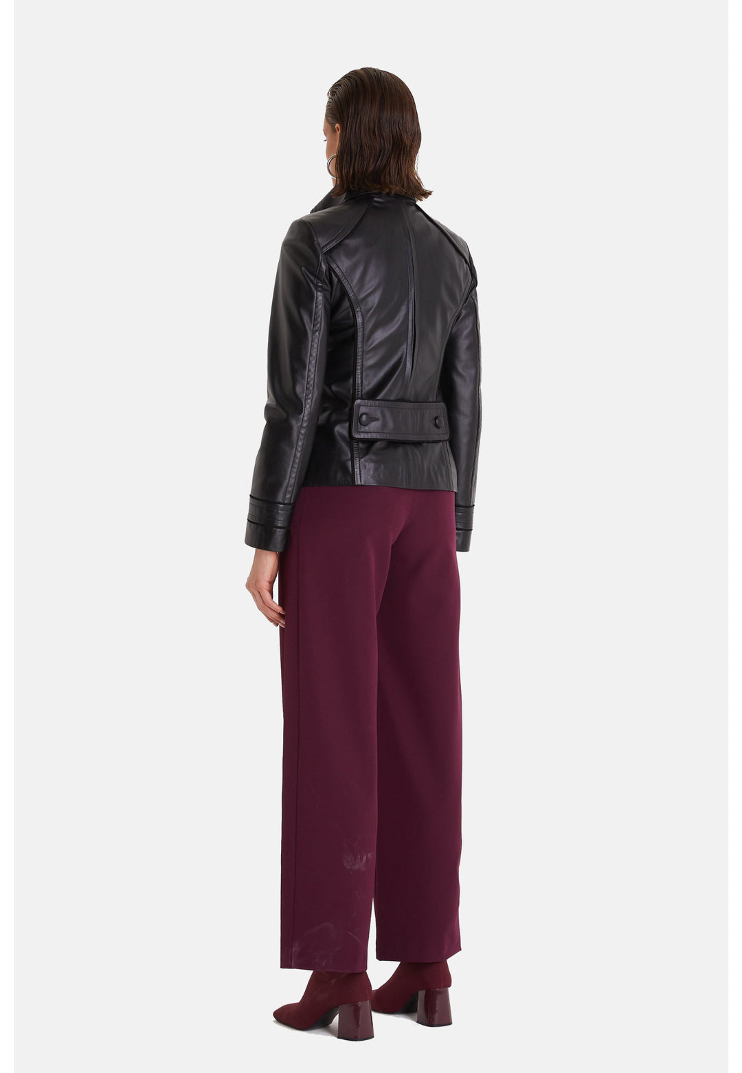 Woman wearing black leather jacket - back view