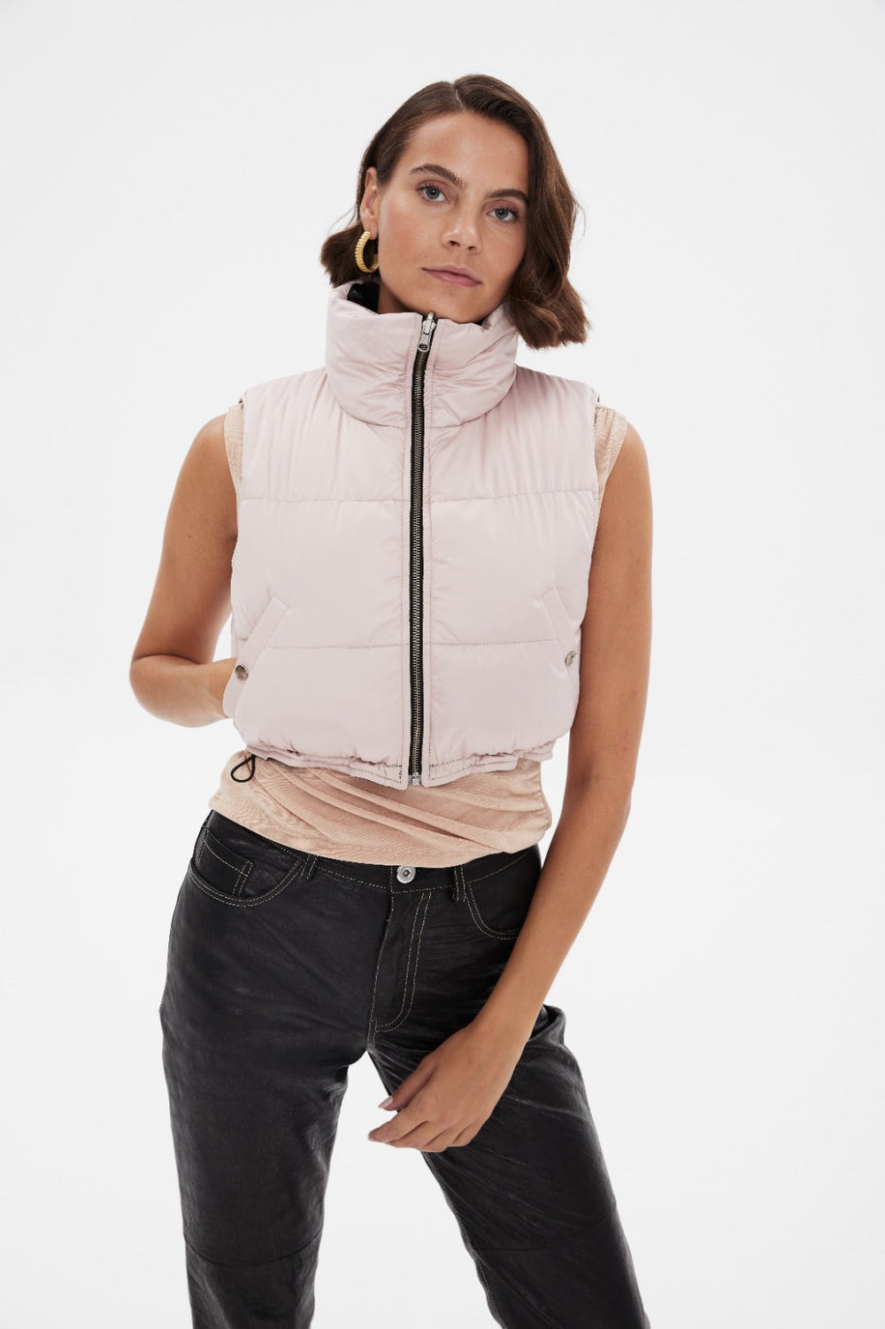 Woman wearing pale pink cropped puffer vest