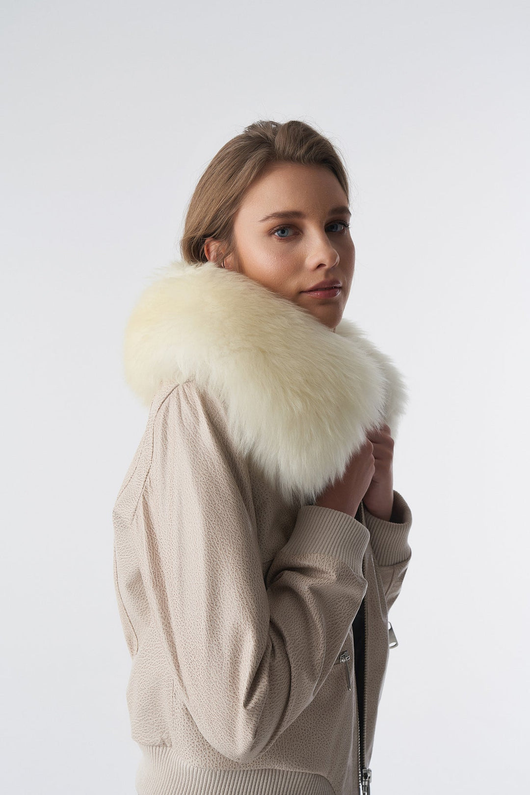 Woman wearing beige bomber jacket with fur
