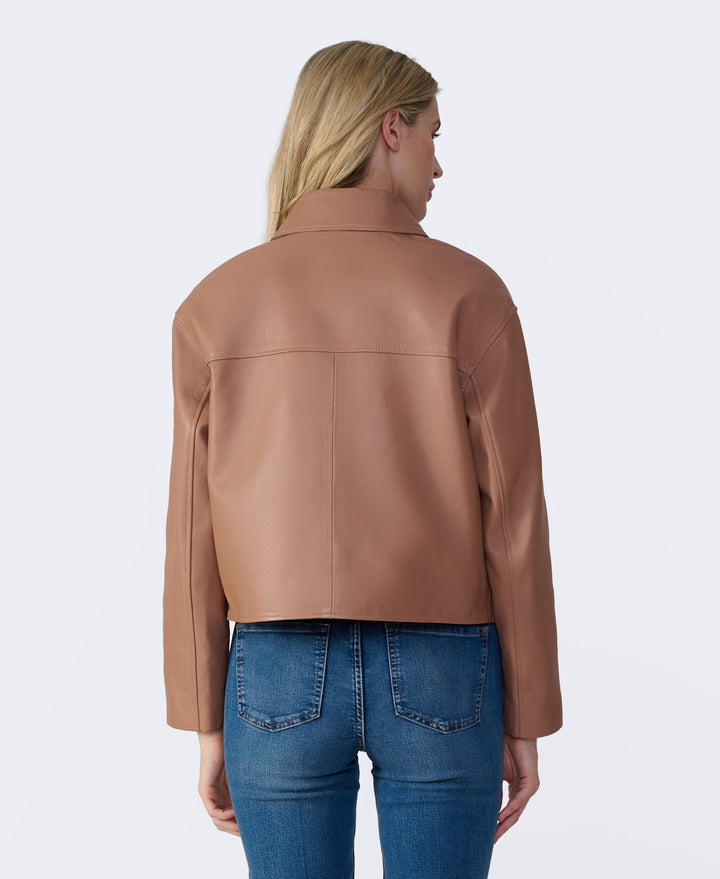 Woman wearing tan leather jacket - back view