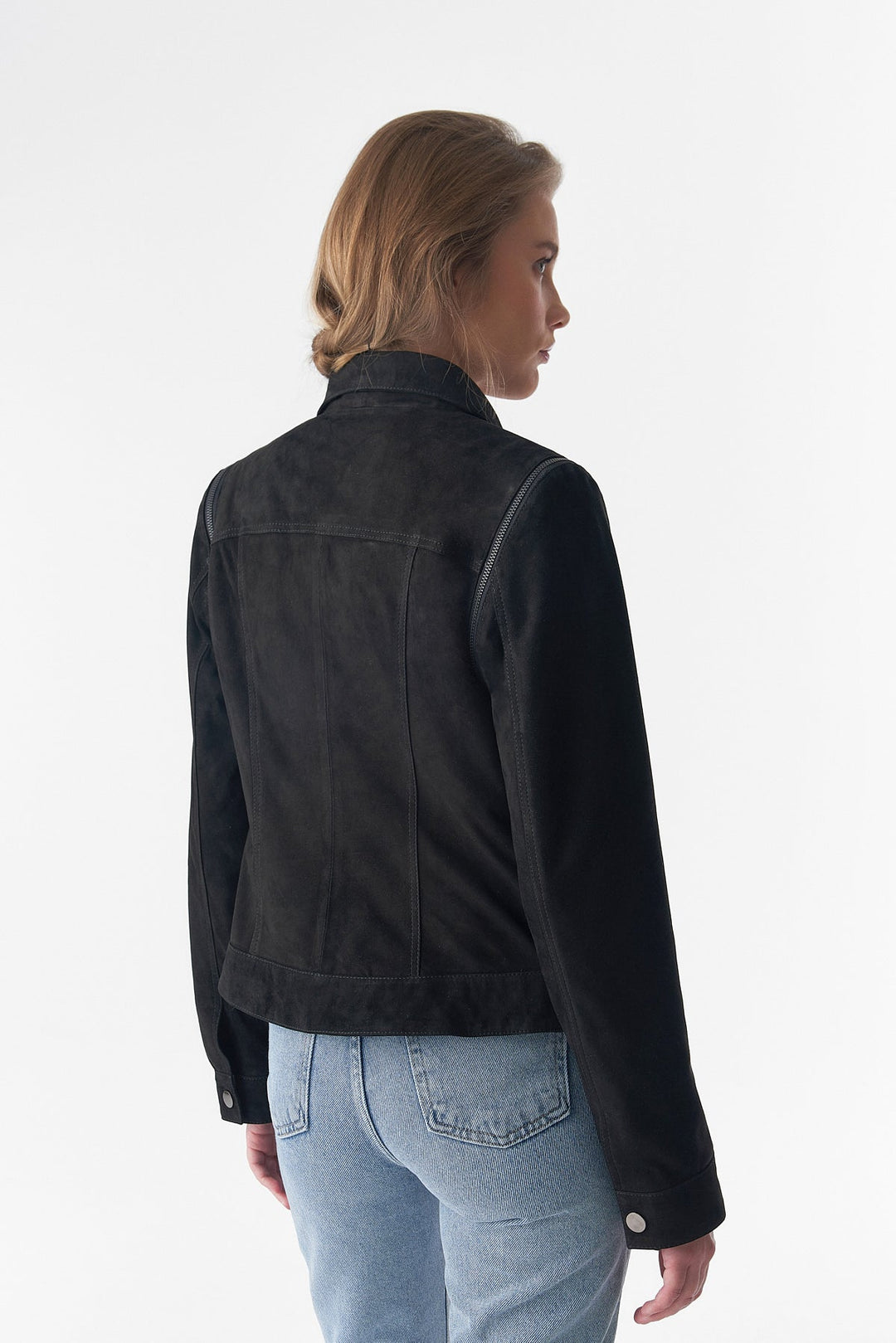 Woman wearing black suede jacket - back view