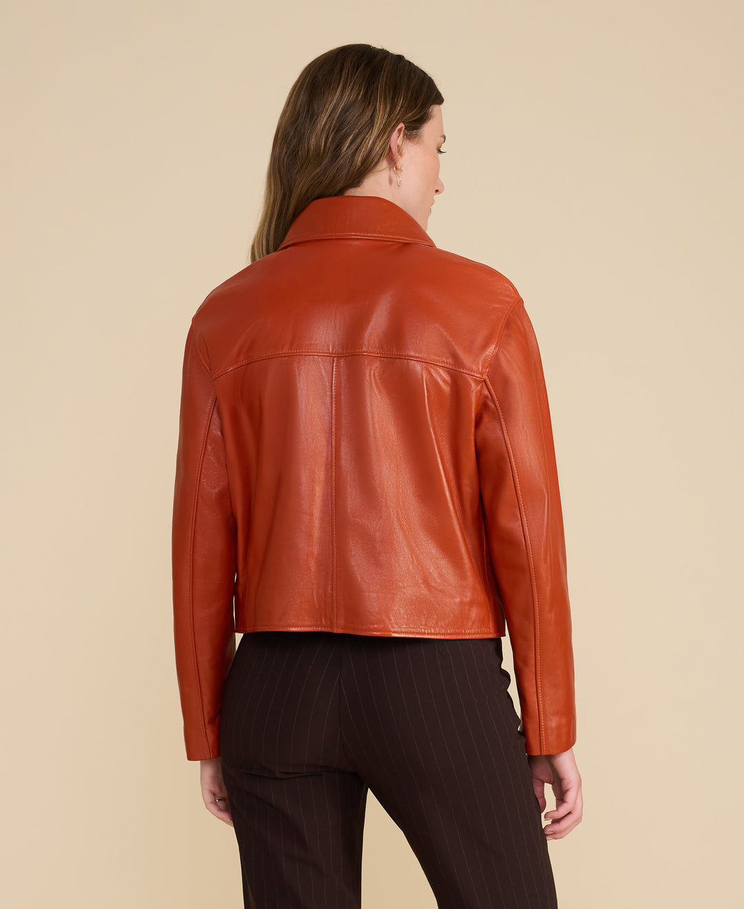 Back of orange leather jacket on model