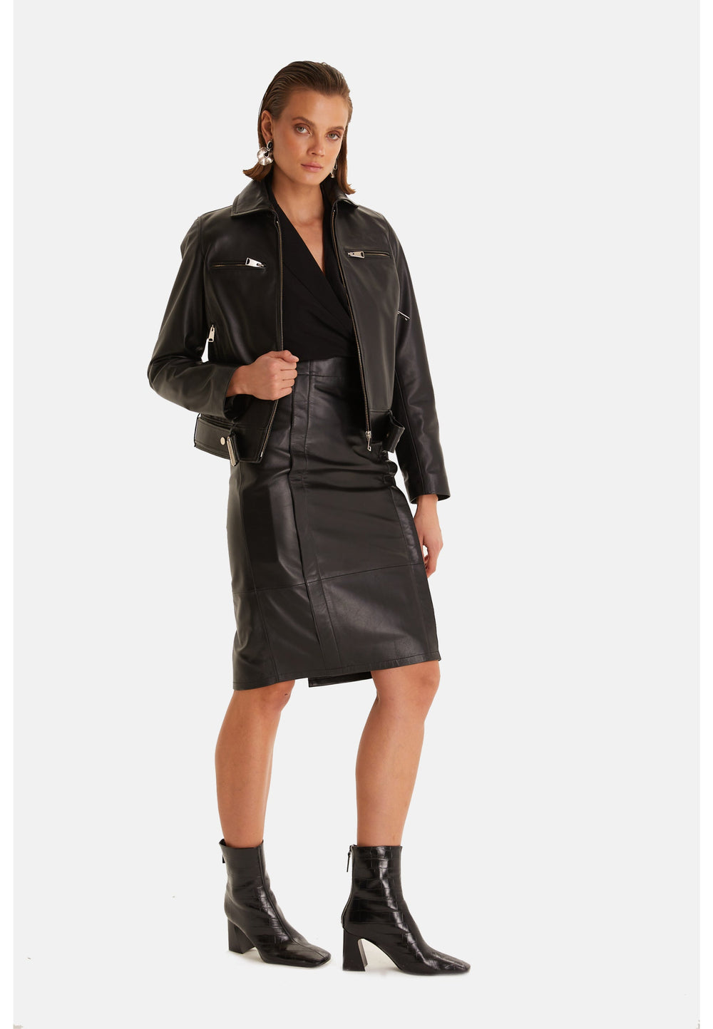 Woman in black leather jacket and skirt