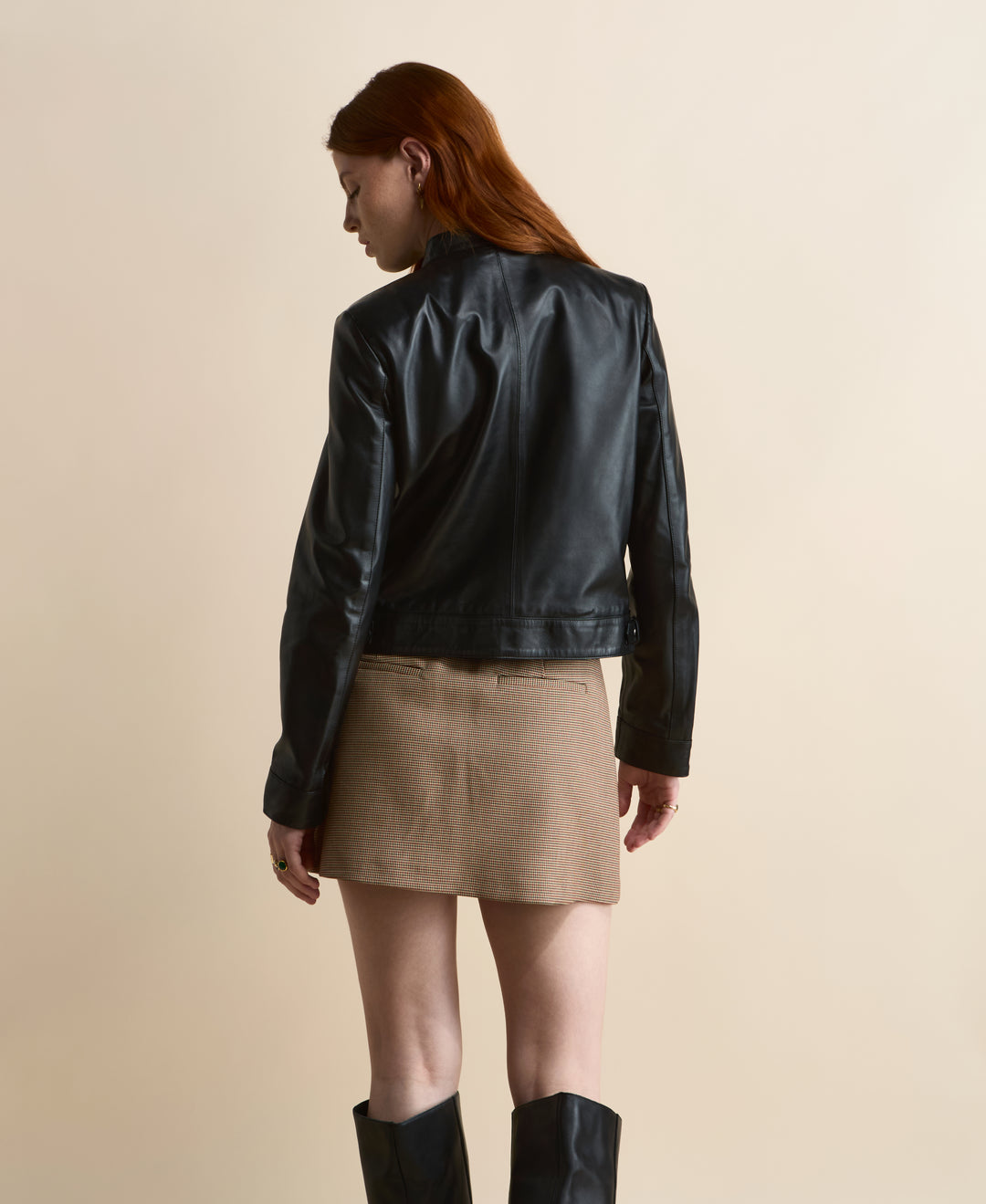 Back view of black leather jacket showing clean panel design and fitted silhouette