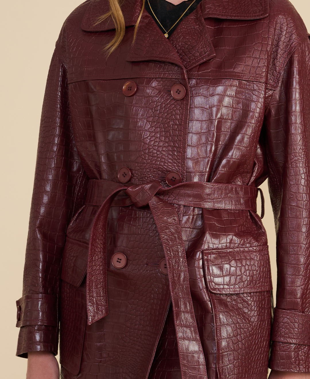 Close-up of burgundy croc-embossed leather texture and double-breasted buttons – premium British leather