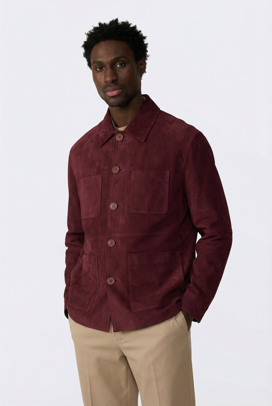 Man wearing a burgundy jacket and beige pants on a white background