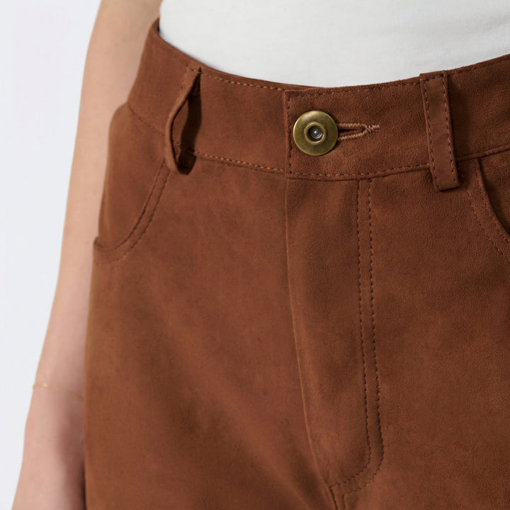 Close-up detail of women's brown suede pants waistband and stitching