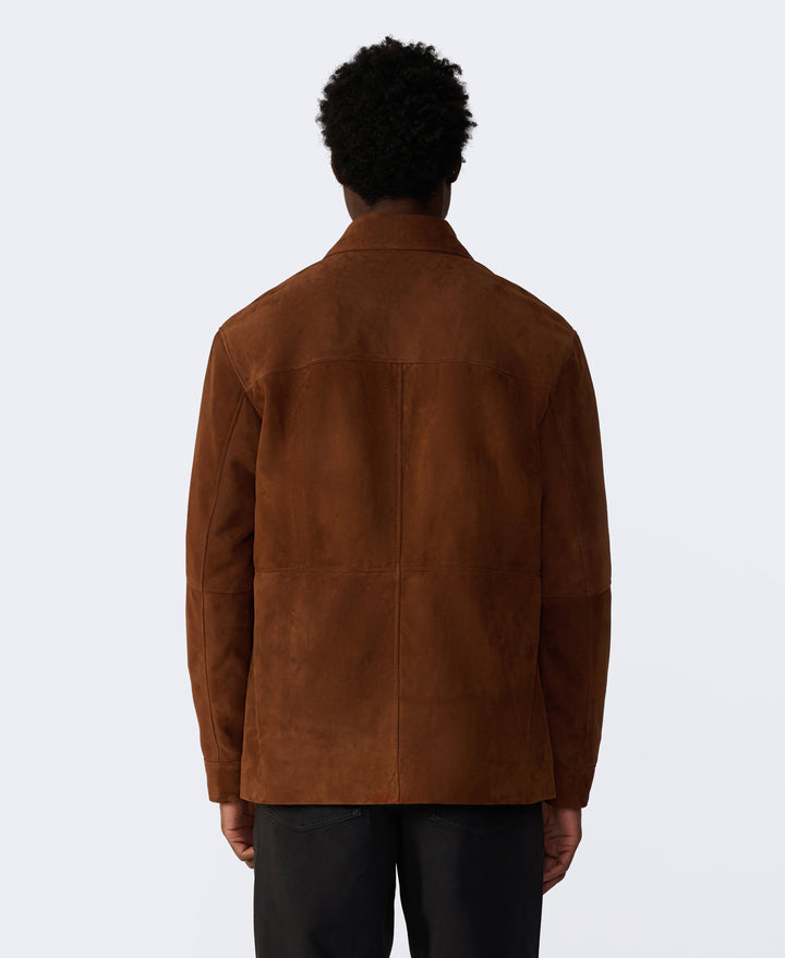 Person wearing a brown suede jacket on a white background