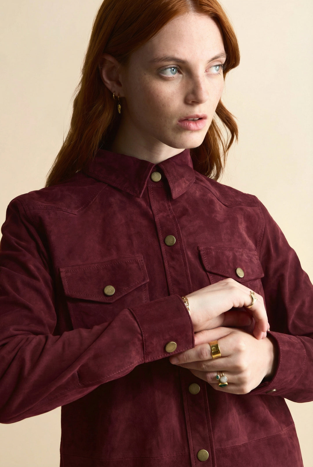 Close-up of burgundy suede shirt with gold snap buttons and chest pockets