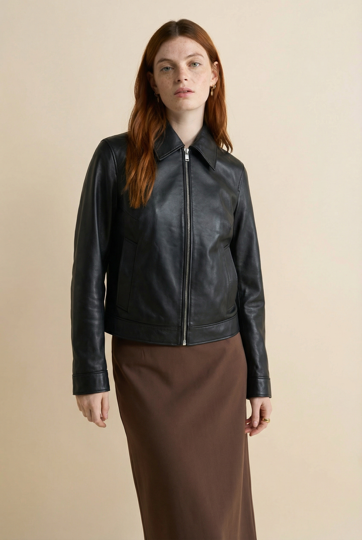 Woman wearing a black leather jacket on a beige background