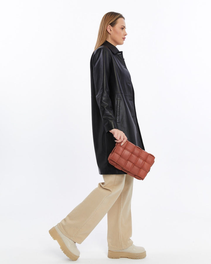 Woman holding cognac quilted leather bag