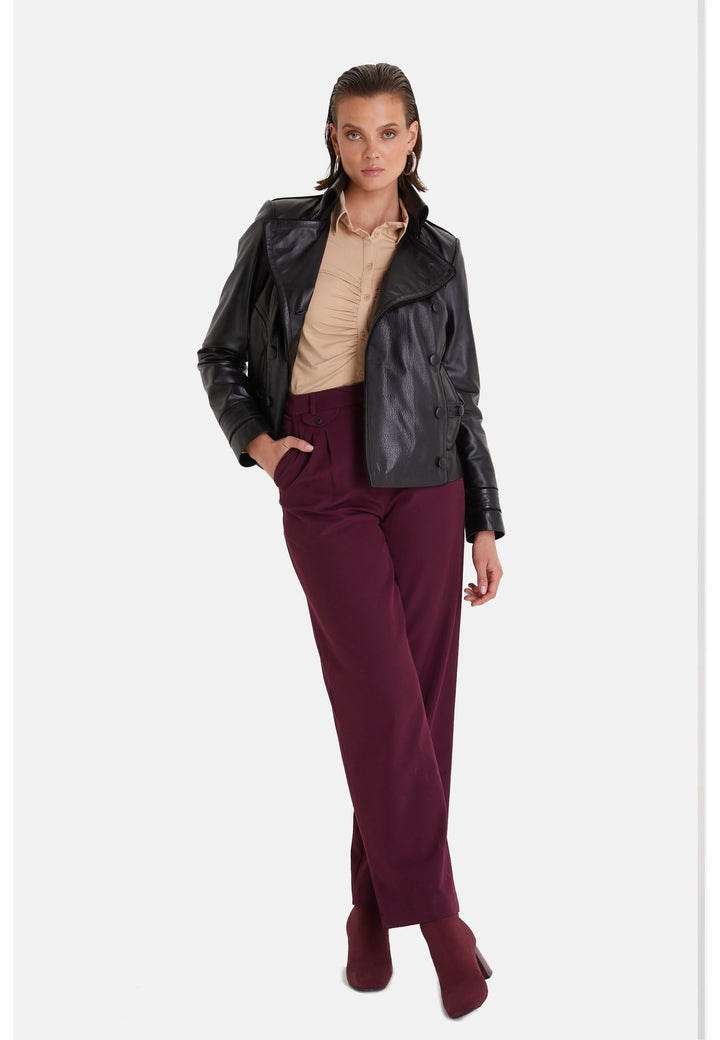 Woman in black leather jacket and burgundy trousers