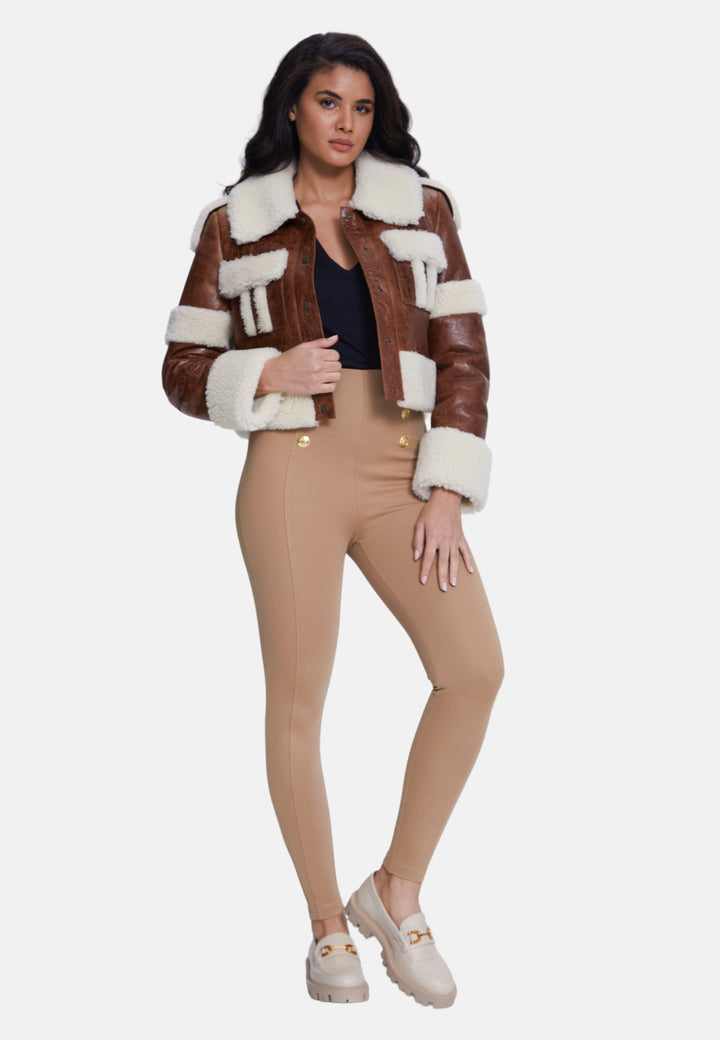 Woman wearing brown shearling cropped jacket