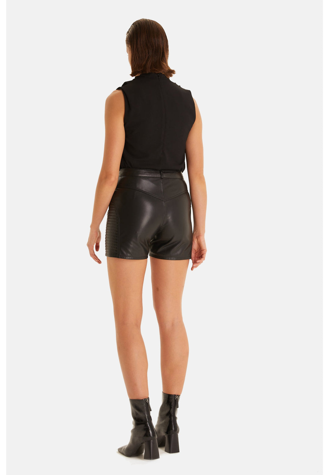 Woman wearing black leather shorts - back view