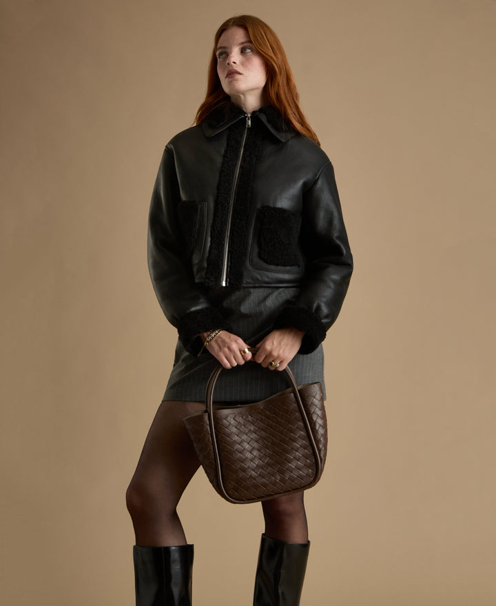 Woman wearing black shearling leather jacket