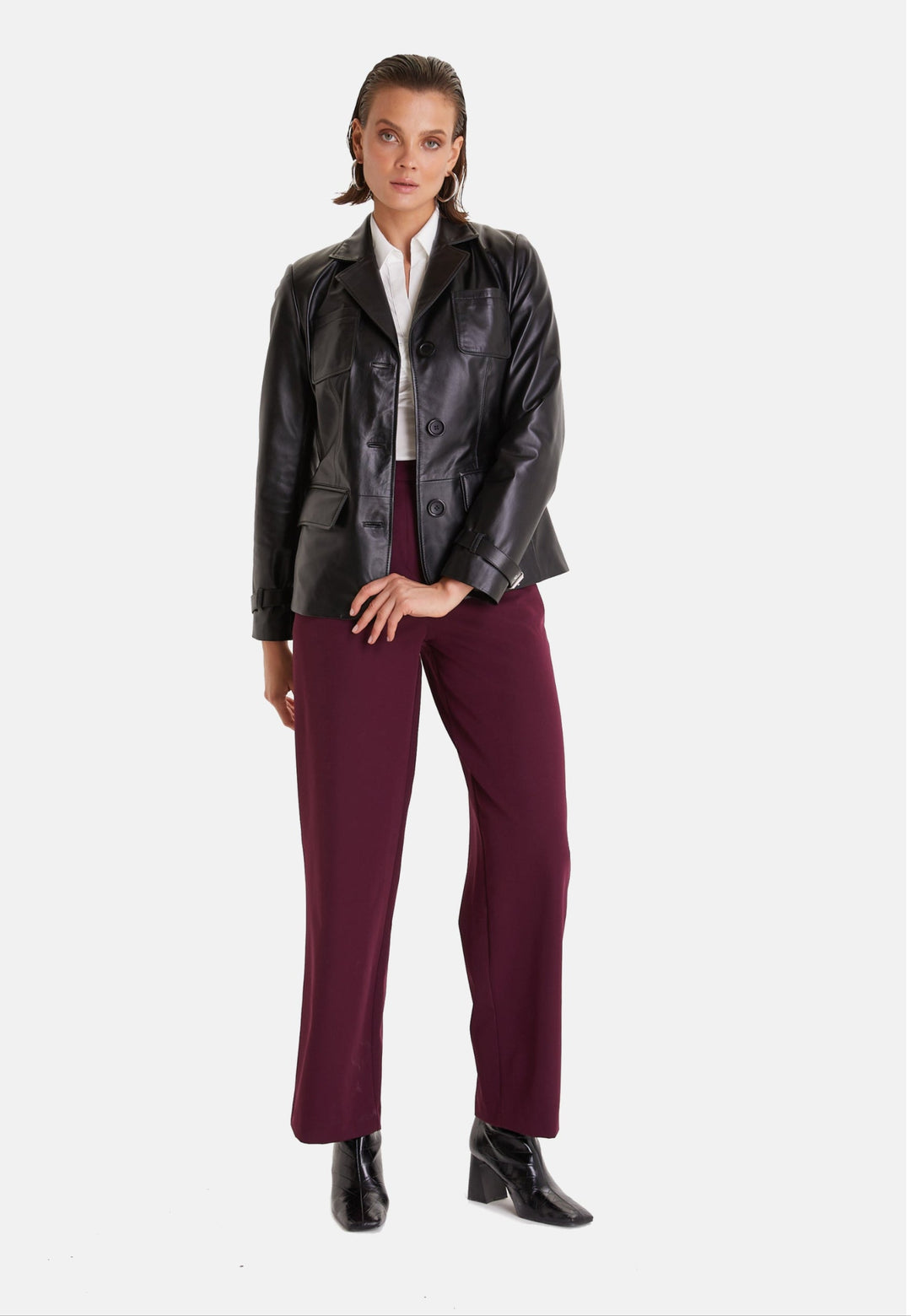 Woman wearing black leather jacket - burgundy trousers