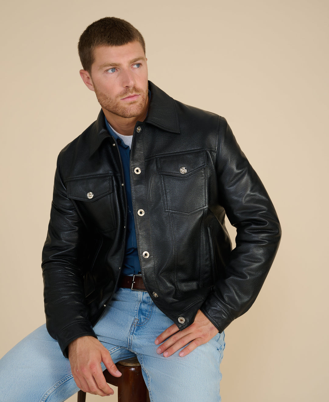 Man wearing black leather jacket seated