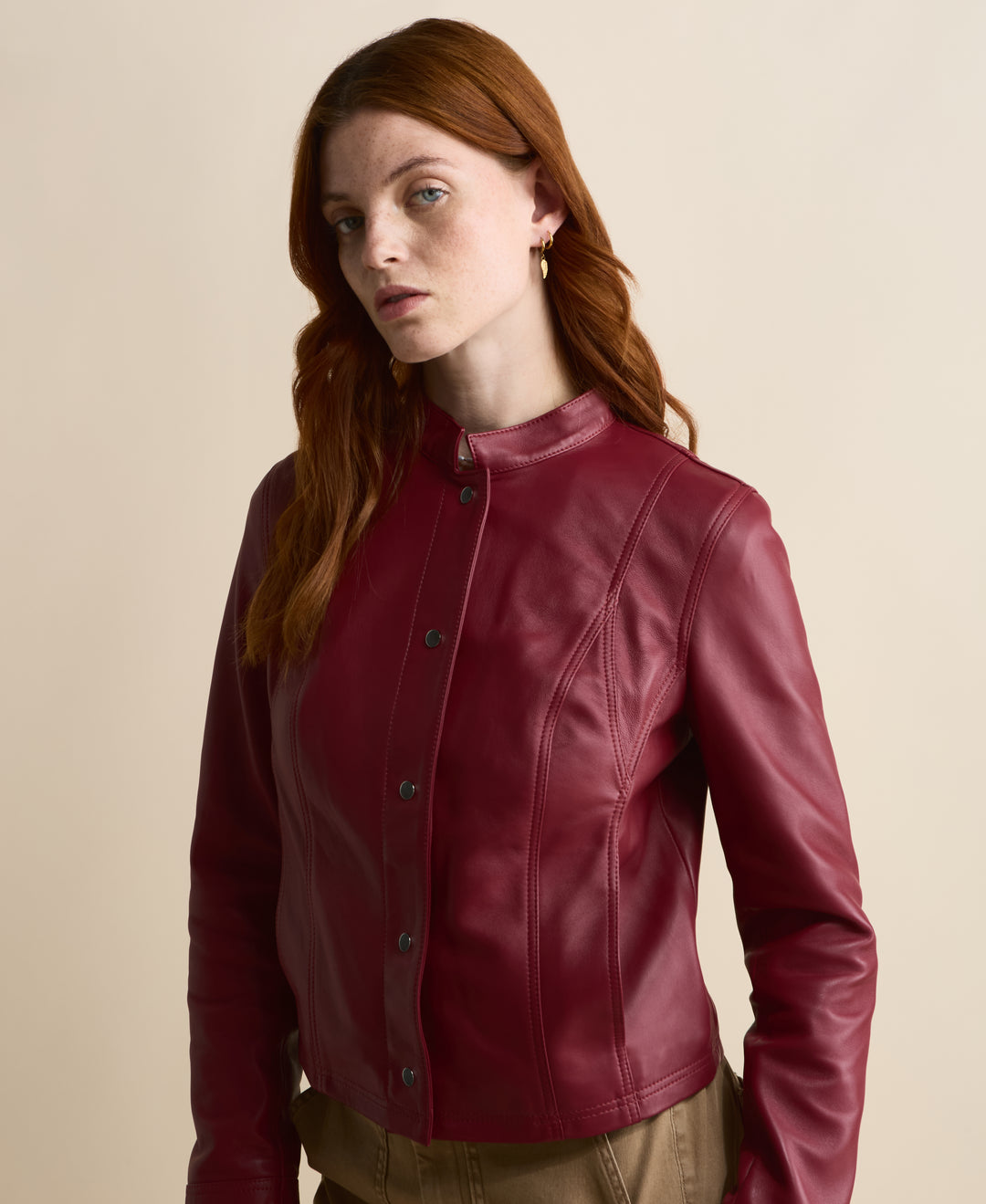 Close-up of Amelia light burgundy leather jacket with stand collar and panel seams