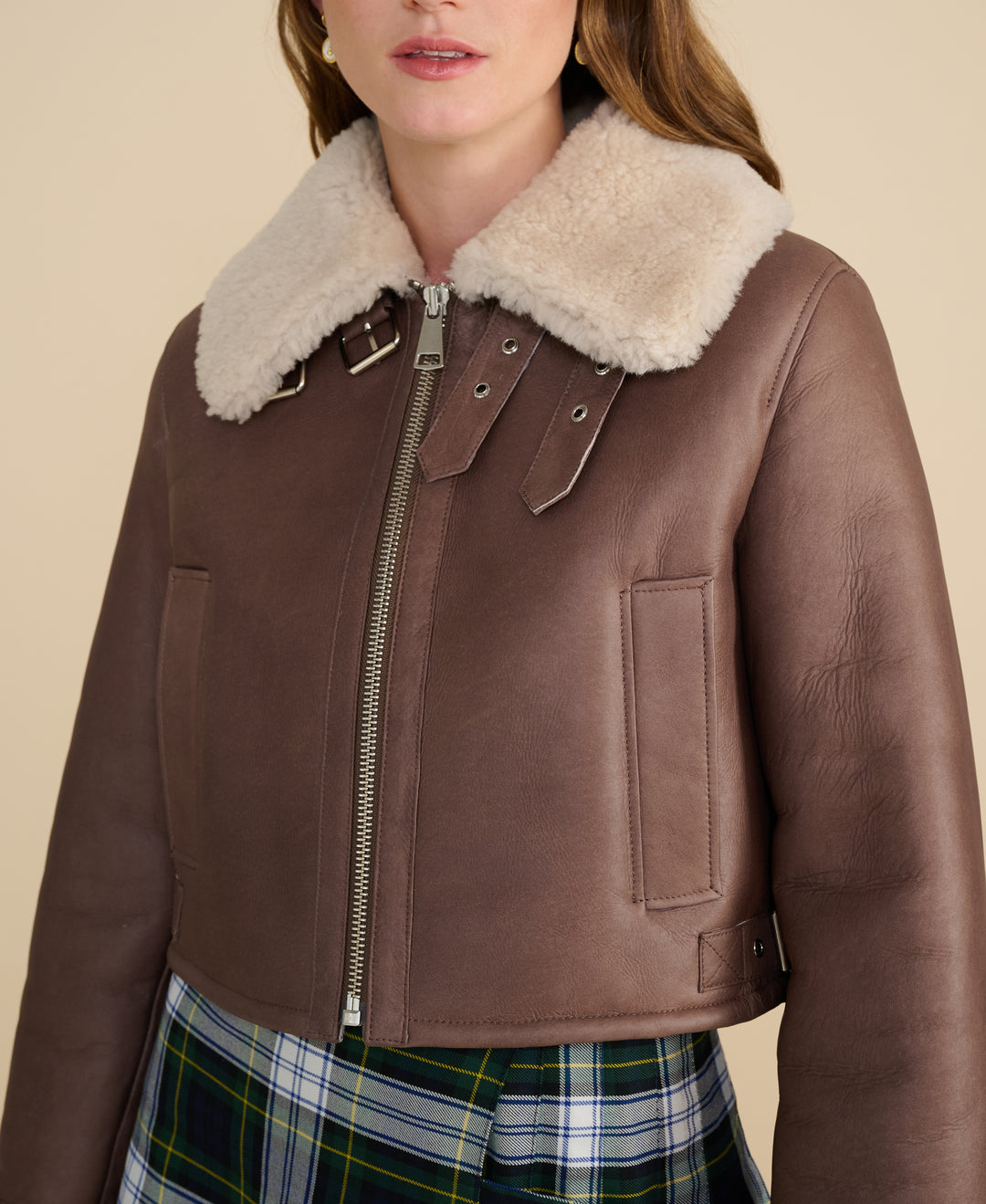 Close-up detail of Avery brown shearling aviator jacket showing beige curly shearling collar and premium hardware