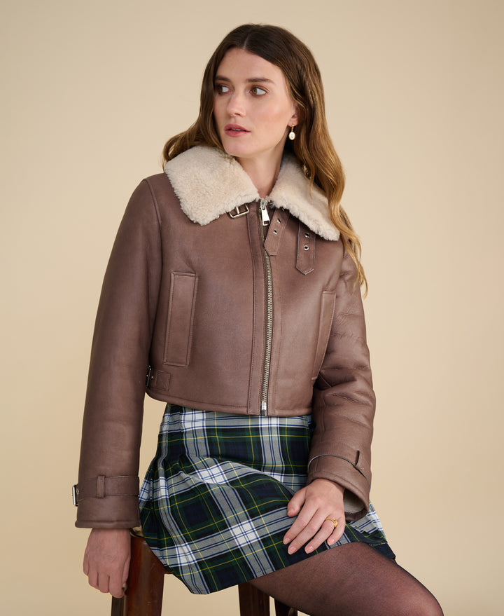 Avery brown shearling aviator jacket styled with plaid skirt for Fall Winter 2026 fashion