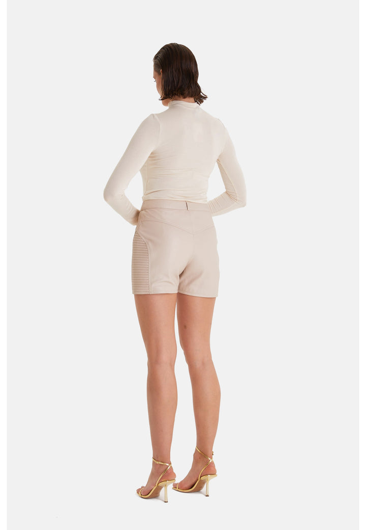 Woman wearing beige leather shorts - back view
