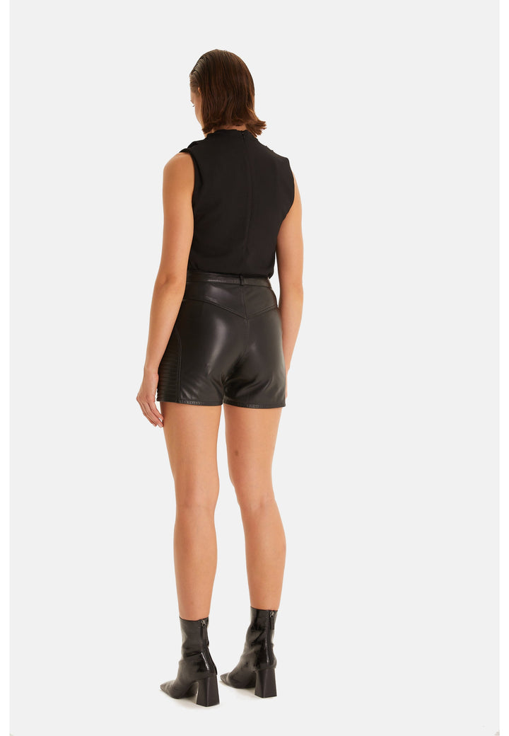 Woman in black leather shorts - back view