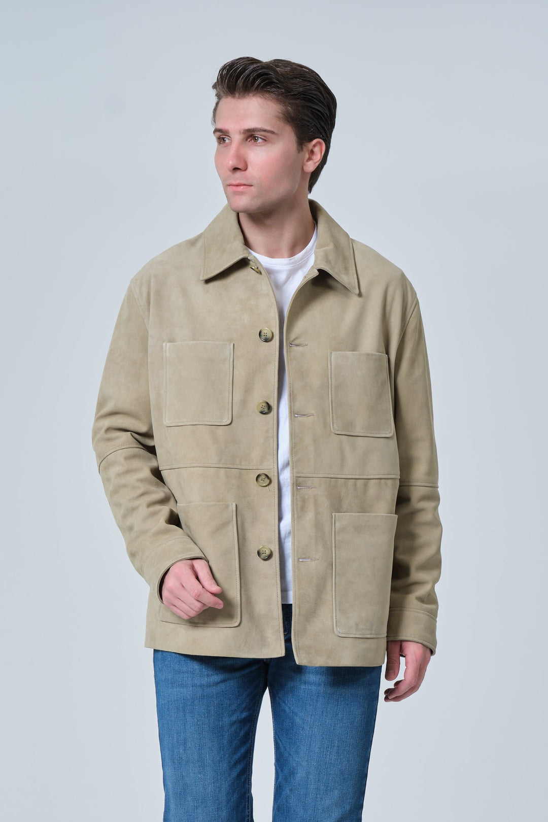 Male model wearing Beckett men's sage green suede chore jacket with blue denim jeans