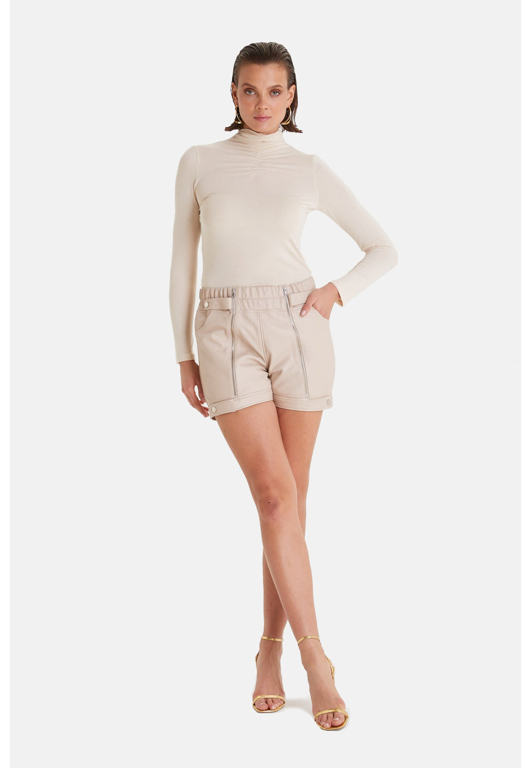 Woman wearing beige leather shorts