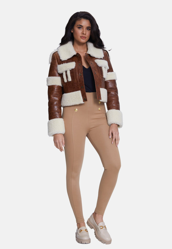 Woman wearing brown shearling cropped jacket