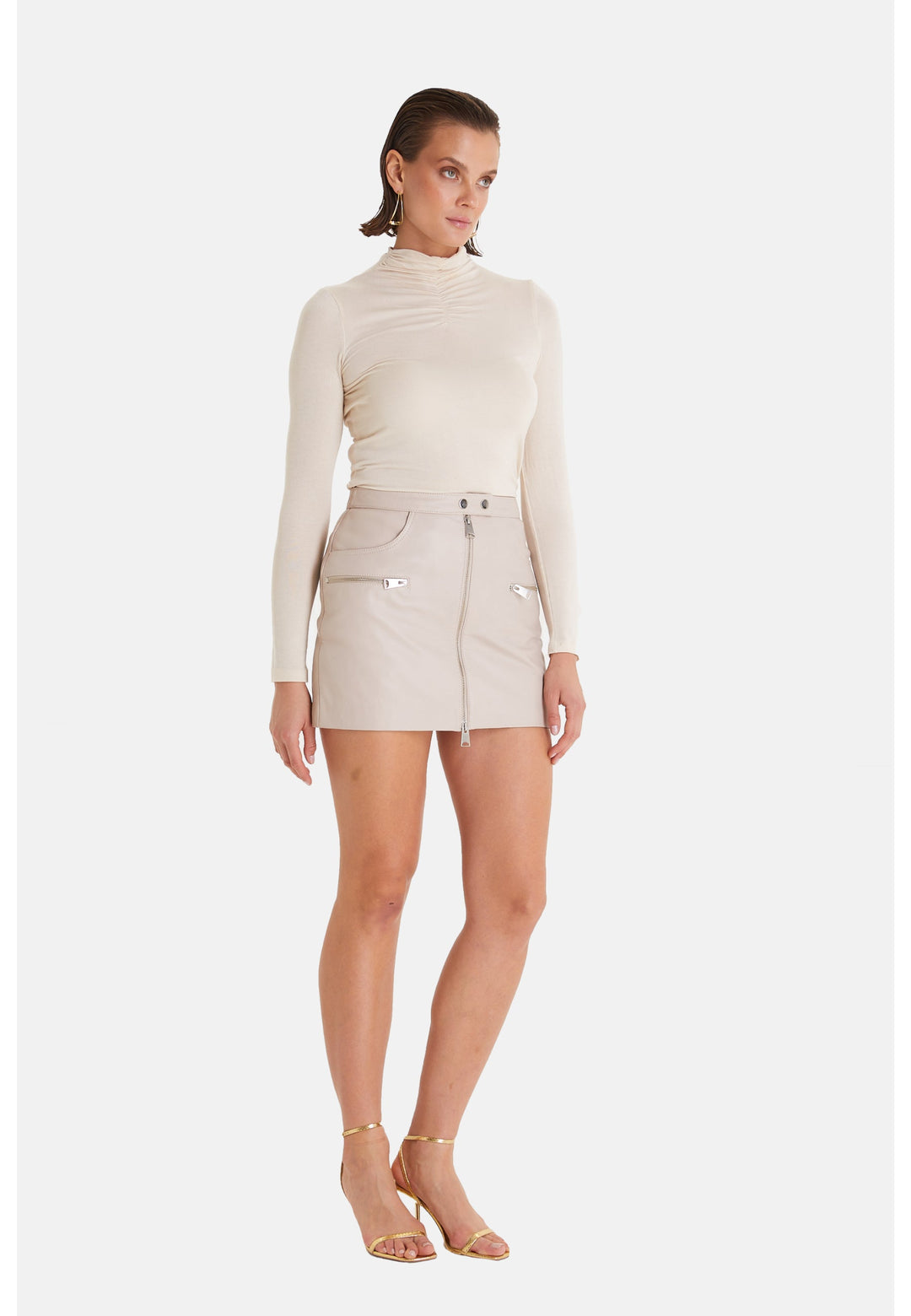 Woman wearing beige leather mini skirt