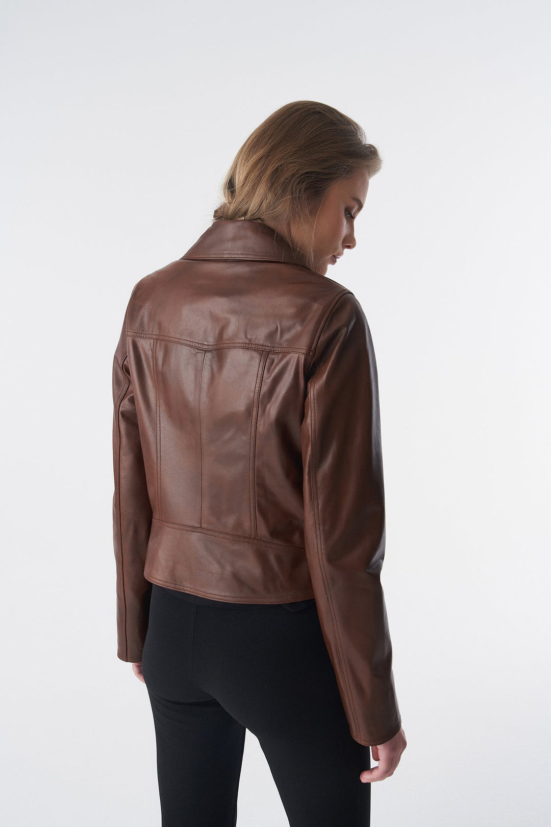 Woman wearing brown leather jacket - back view