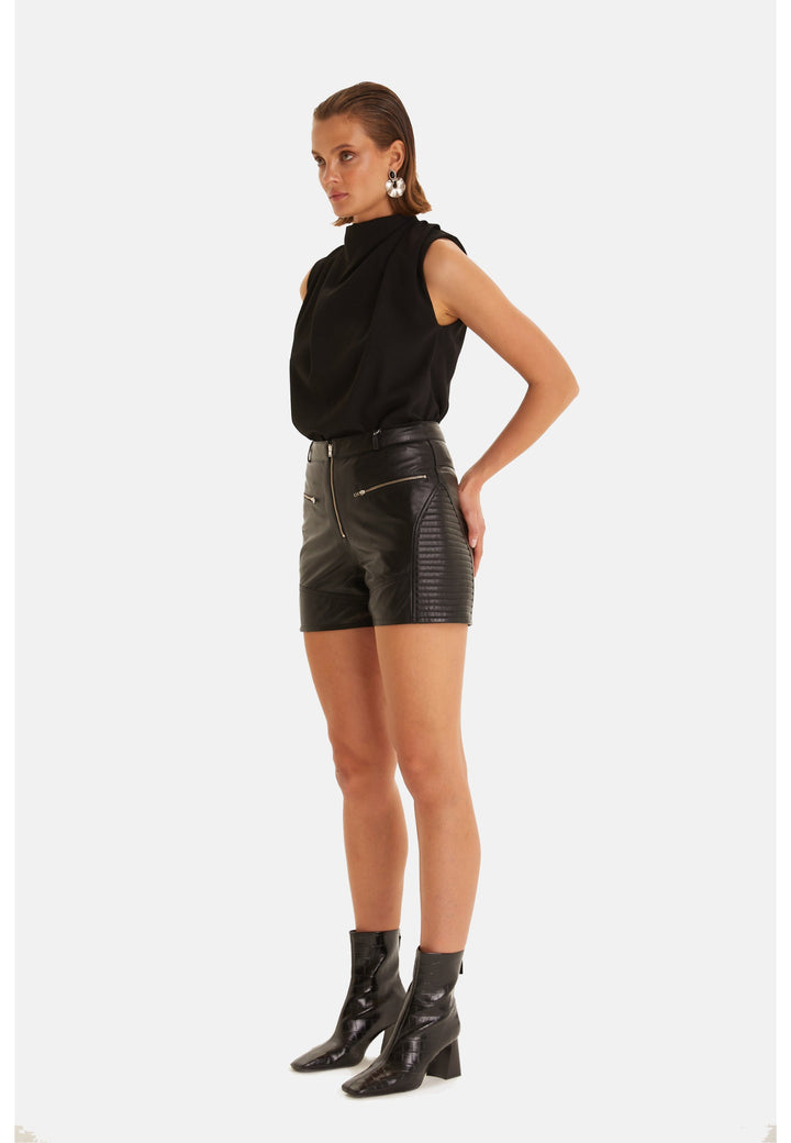 Woman wearing black leather shorts