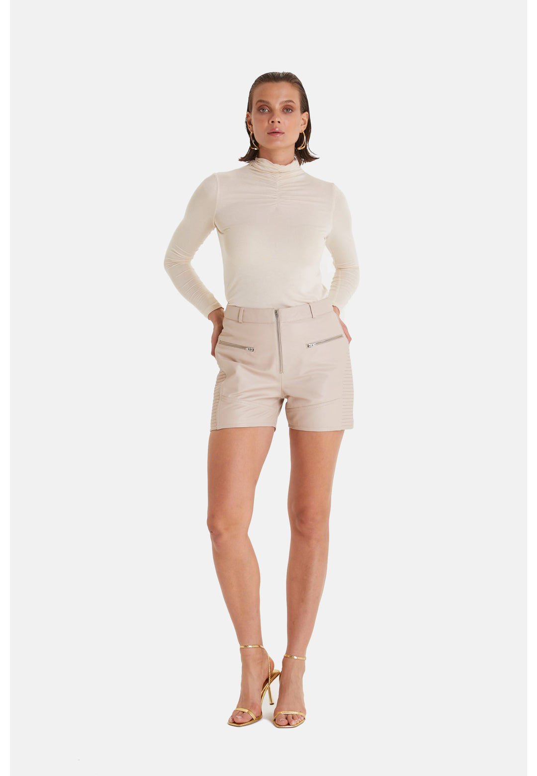 Woman wearing beige leather shorts