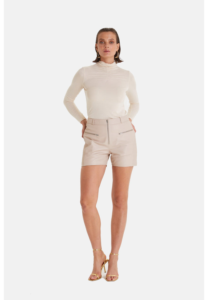 Woman wearing beige leather shorts