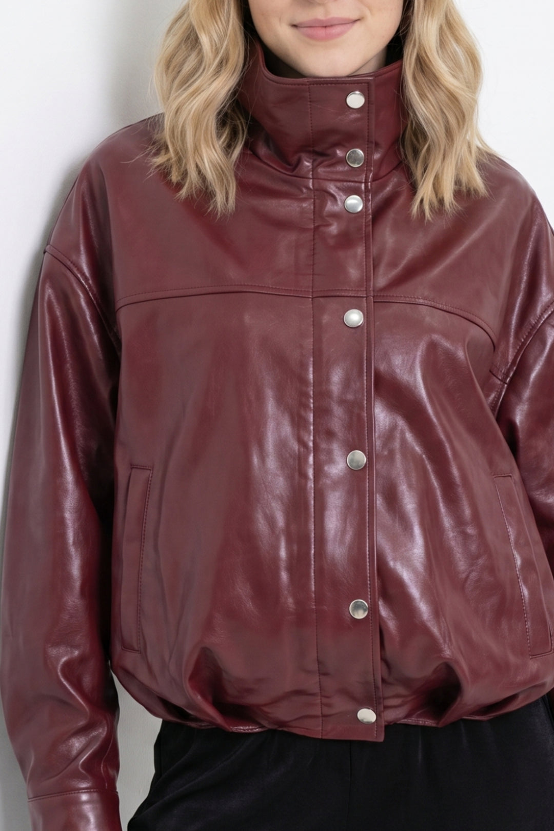 Close-up detail burgundy leather jacket snap buttons and texture