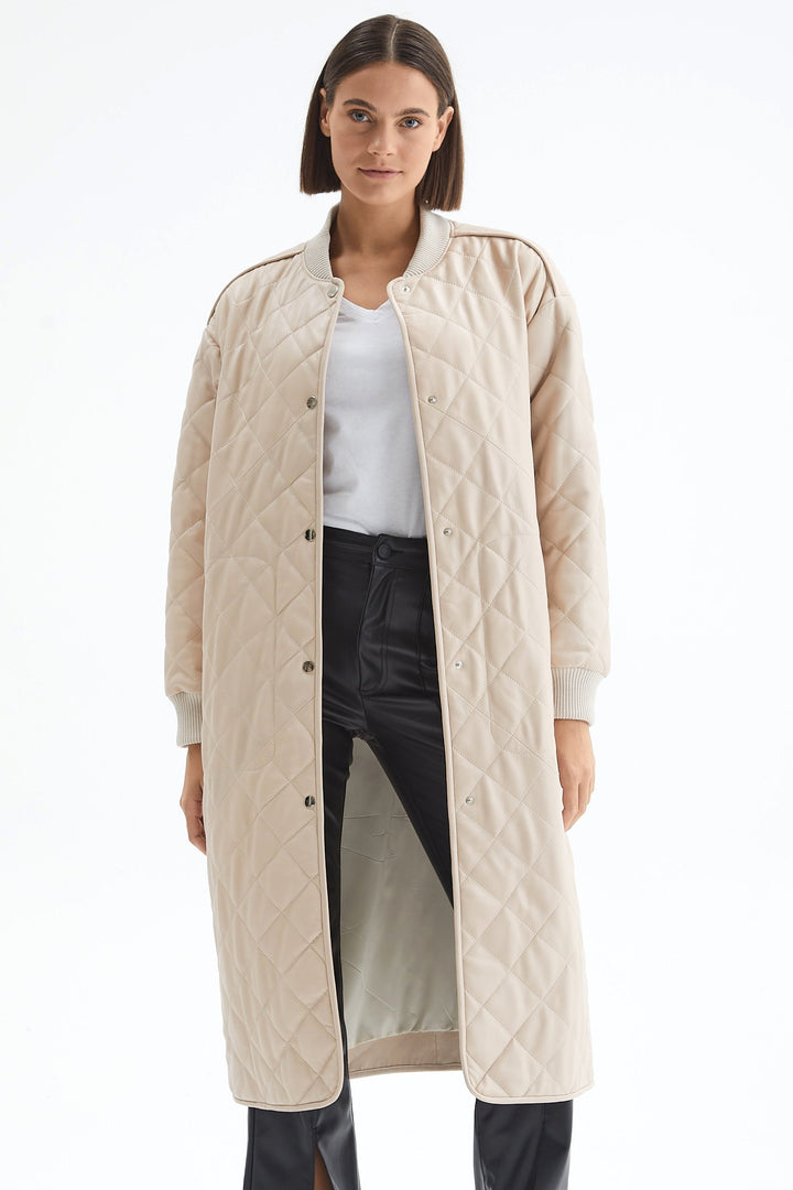 Front view of the Kensington beige quilted leather coat worn open, showing the lining and longline silhouette.